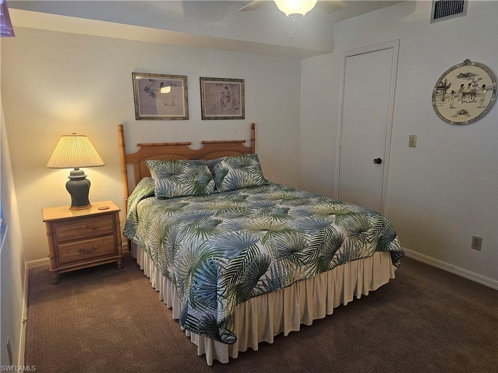 Bedroom with dark colored carpet and ceiling fan