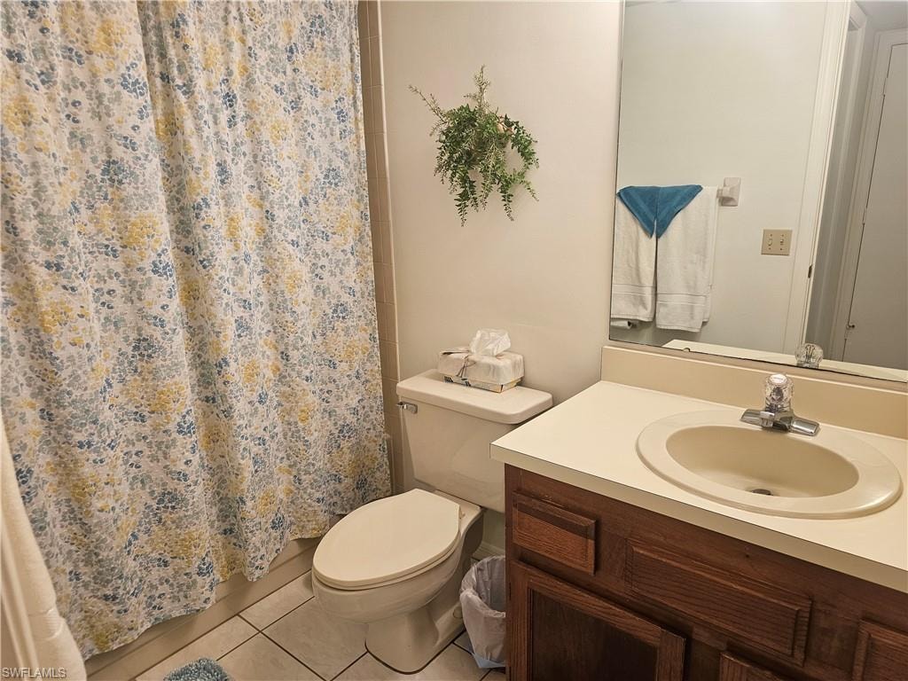 Bathroom with tile patterned flooring, curtained shower, and vanity