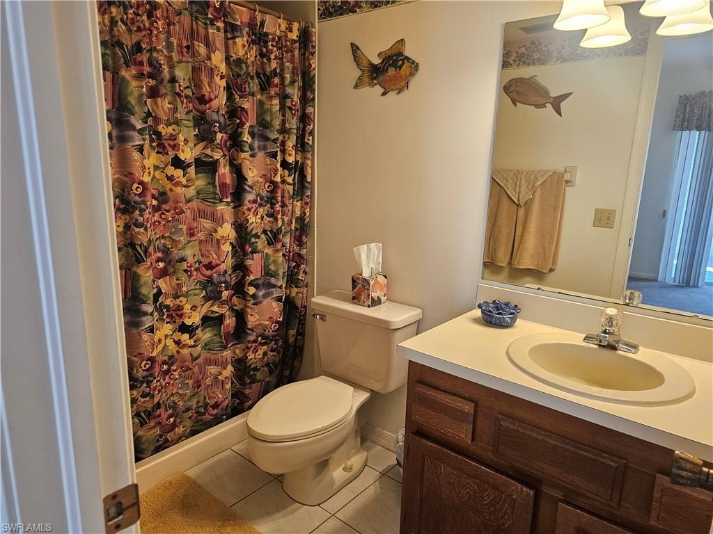 Full bath featuring tile patterned flooring, curtained shower, and vanity