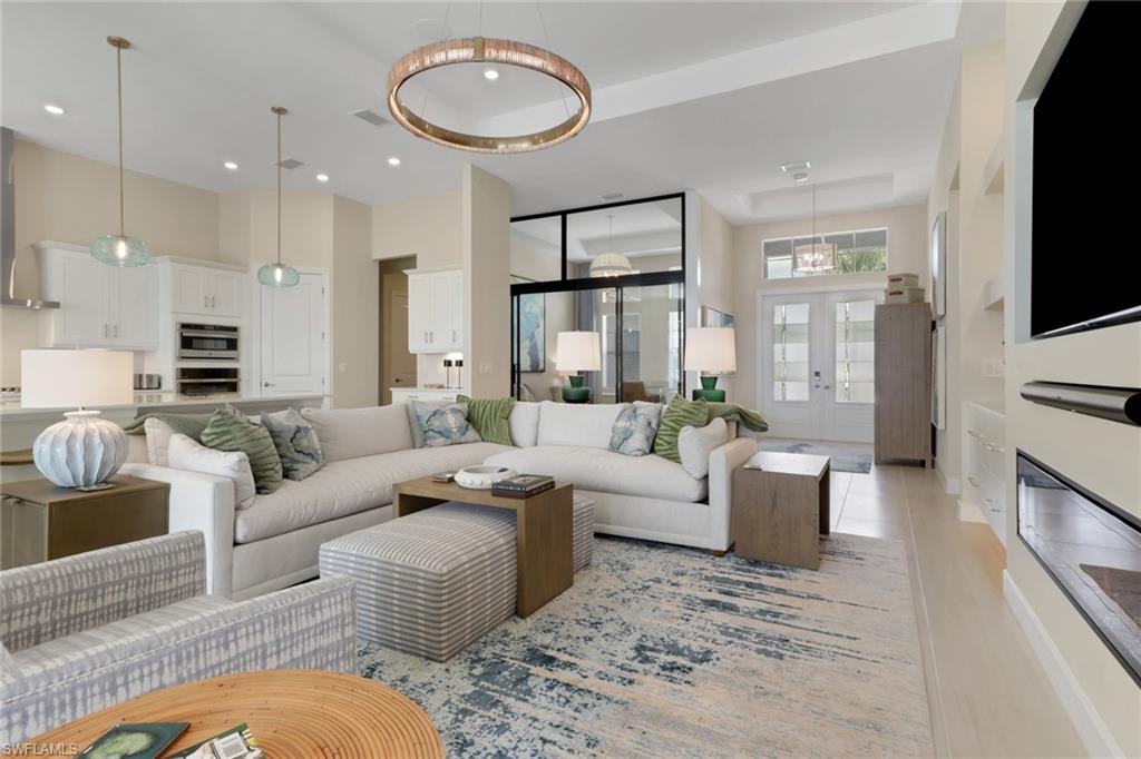 Living room featuring french doors, recessed lighting, and a towering ceiling