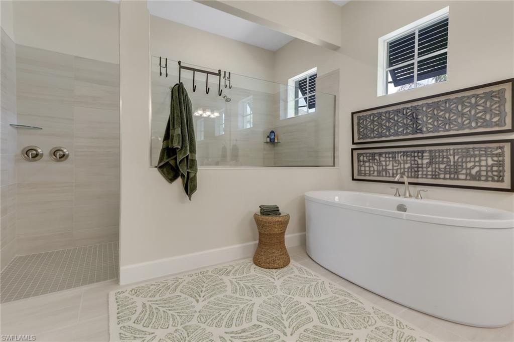 Full bath featuring walk in shower, tile patterned floors, and a soaking tub