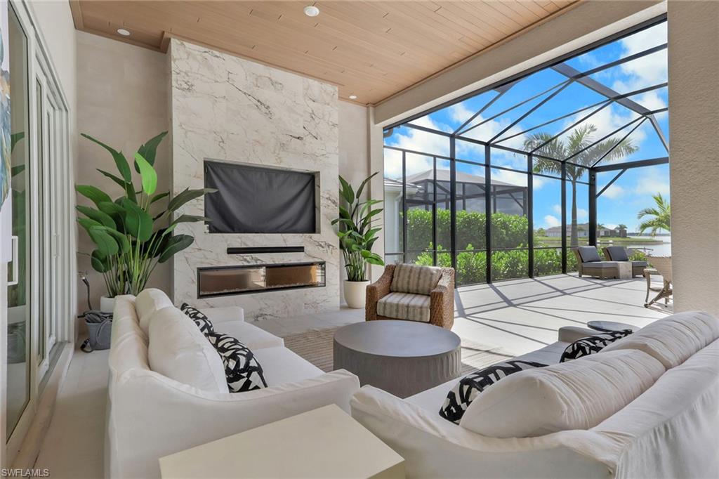 View of patio / terrace with a sunroom, glass enclosure, an outdoor pool, outdoor dining space, and a water view