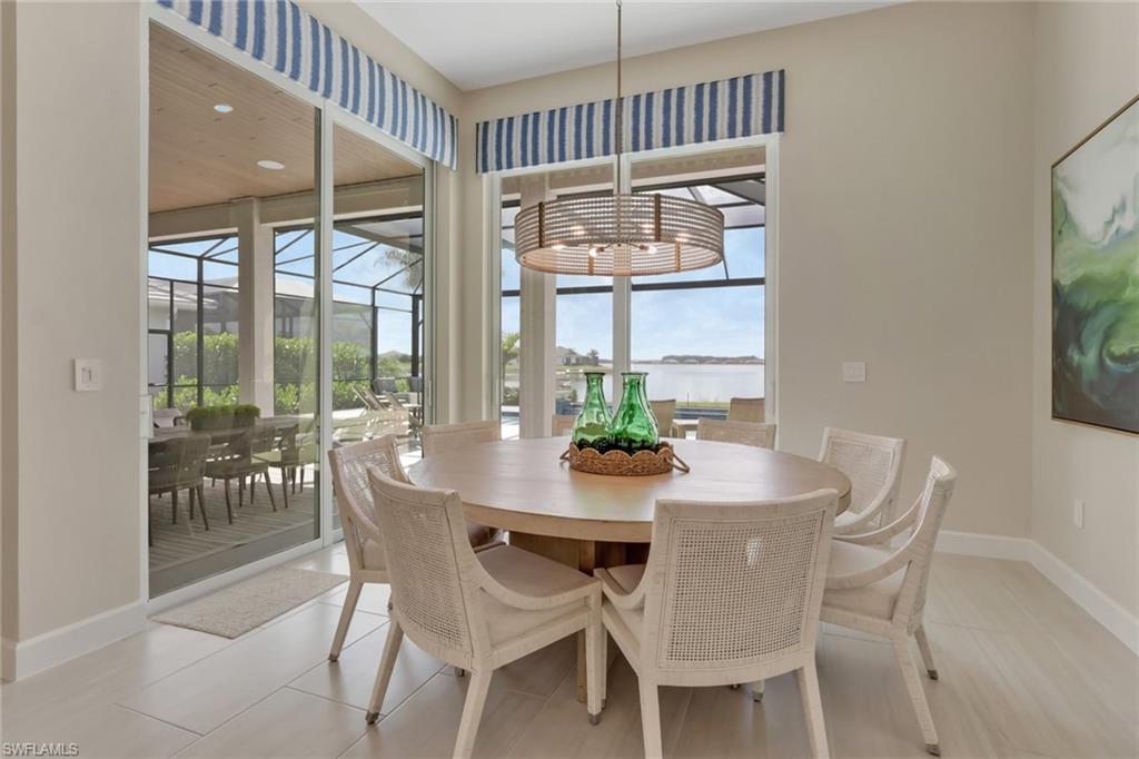 Dining area featuring a sunroom, a water view, recessed lighting, and light tile patterned floors