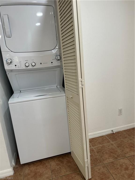 Laundry area featuring stacked washer / drying machine and tile patterned floors