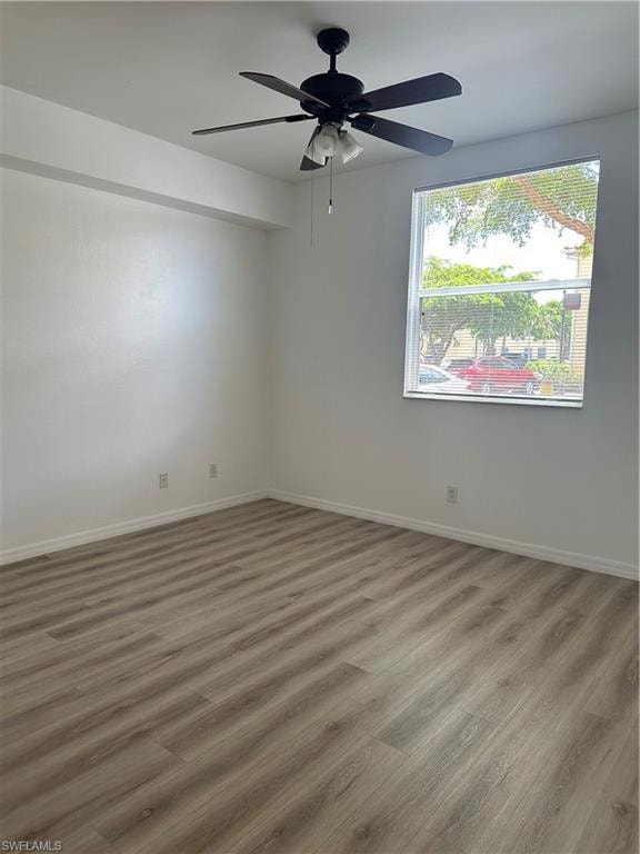 Spare room with hardwood / wood-style floors and ceiling fan