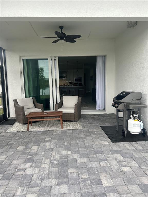 View of patio featuring area for grilling and ceiling fan