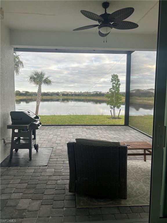 View of patio / terrace featuring area for grilling, ceiling fan, and a water view