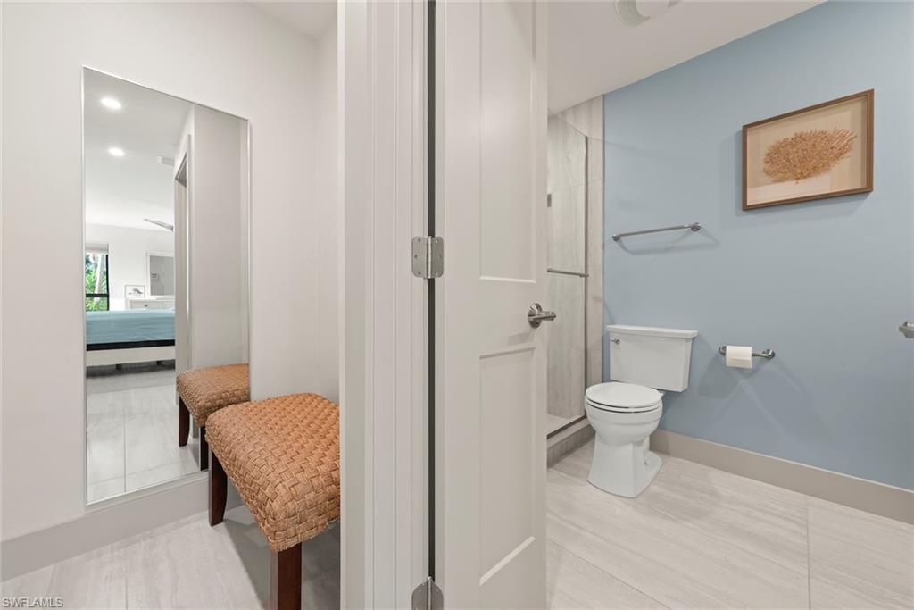 Full bathroom featuring connected bathroom, a stall shower, recessed lighting, and tile patterned flooring