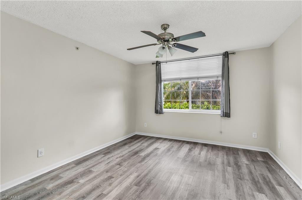 Spare room featuring a textured ceiling, light wood-style floors, and ceiling fan
