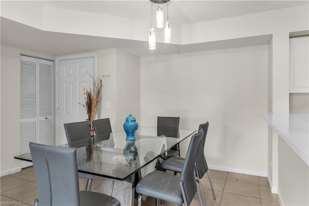 Dining room featuring light tile patterned flooring and a textured ceiling