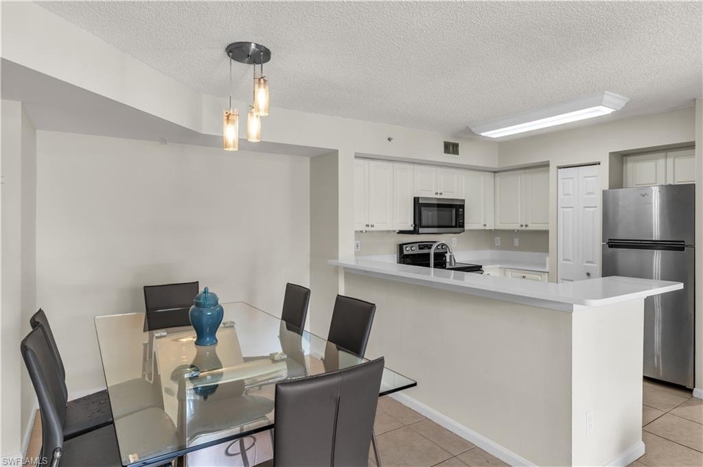 Dining room featuring light tile patterned floors and a textured ceiling