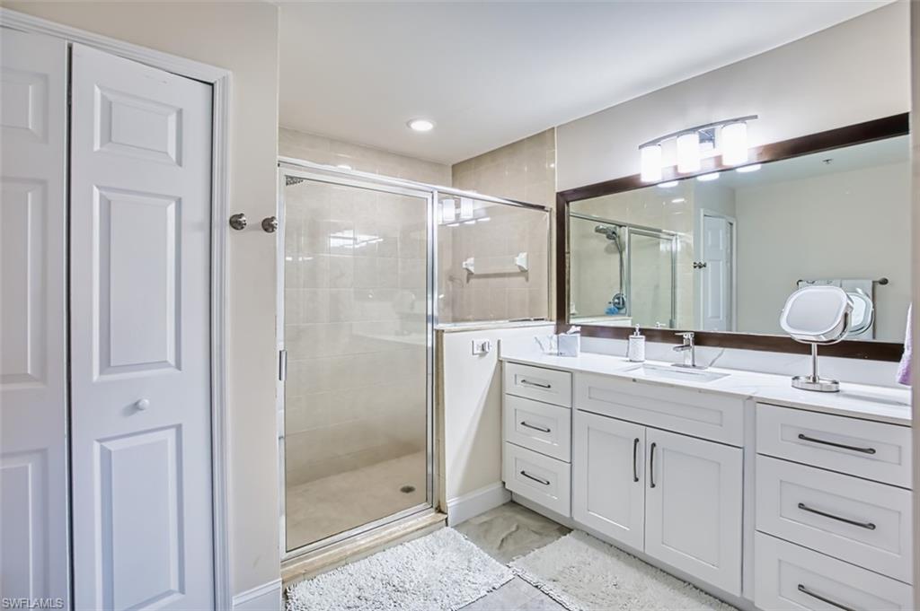 Full bath with vanity, a shower stall, a closet, and recessed lighting