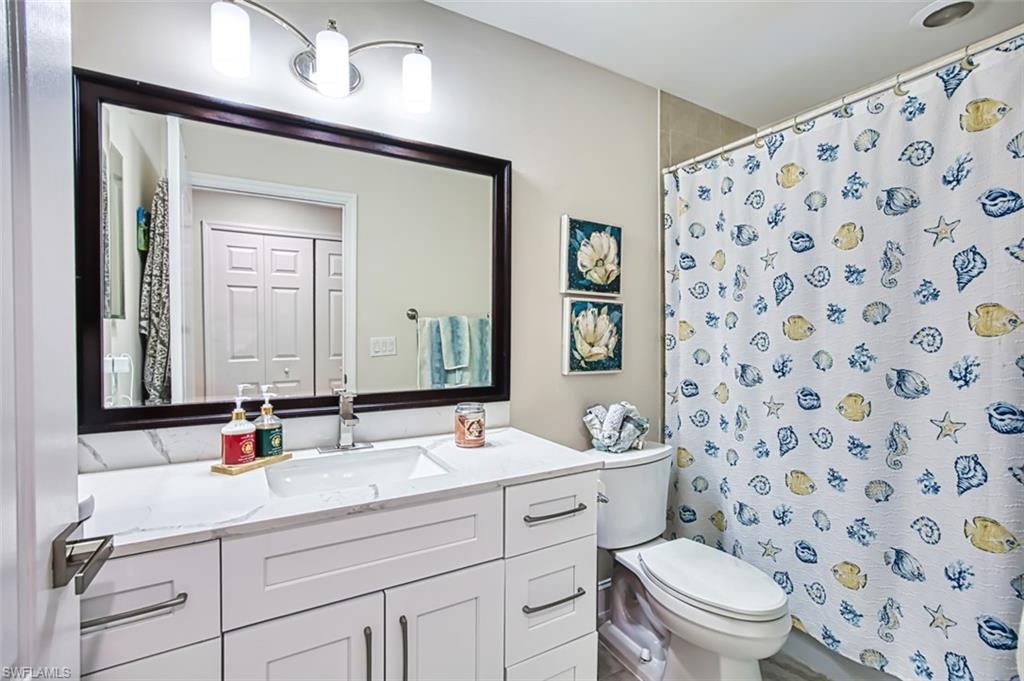 Bathroom with a shower with shower curtain and vanity