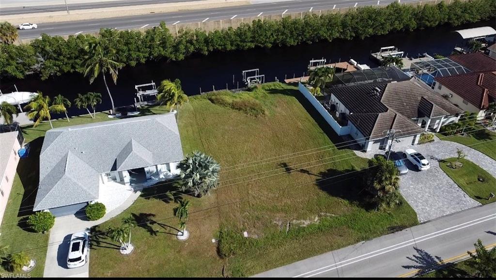 Aerial view of property and surrounding area featuring a nearby body of water