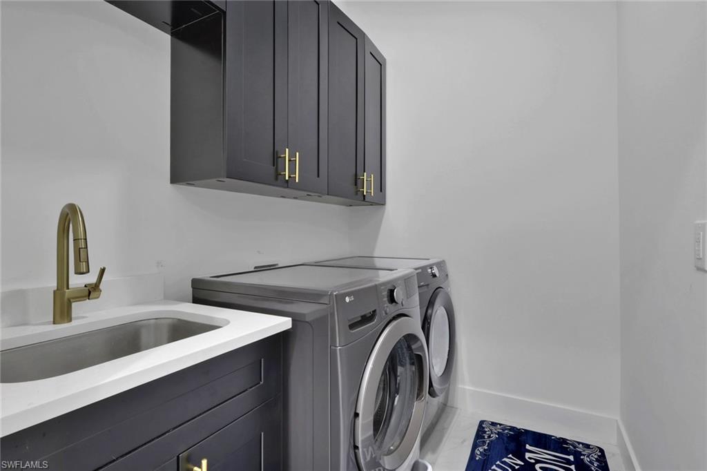 Laundry area featuring separate washer and dryer and cabinet space