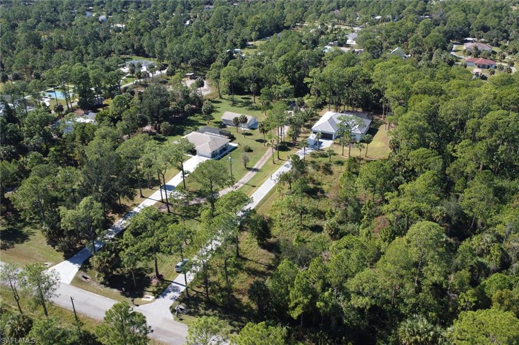 Aerial view of property and surrounding area with a heavily wooded area
