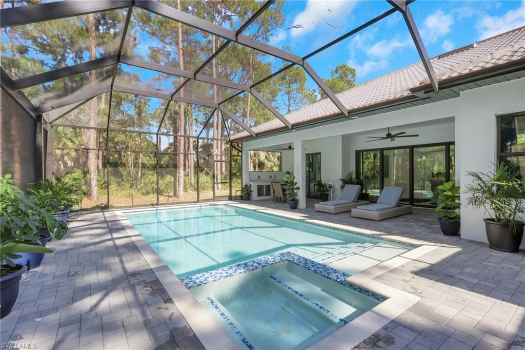 View of pool with a ceiling fan, a patio, a lanai, and a pool with connected hot tub