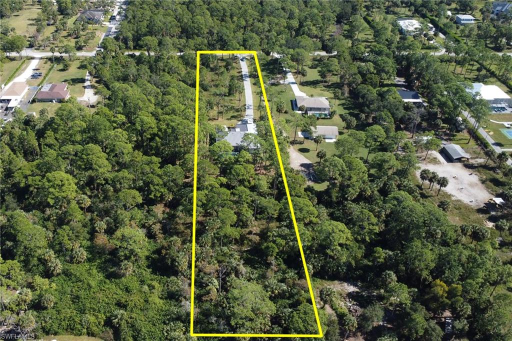 Aerial view of property's location featuring property parcel outlined and a forest