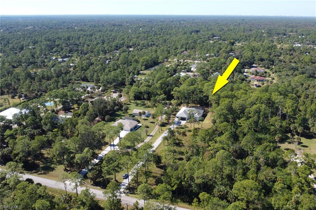 Aerial view of property's location with a heavily wooded area