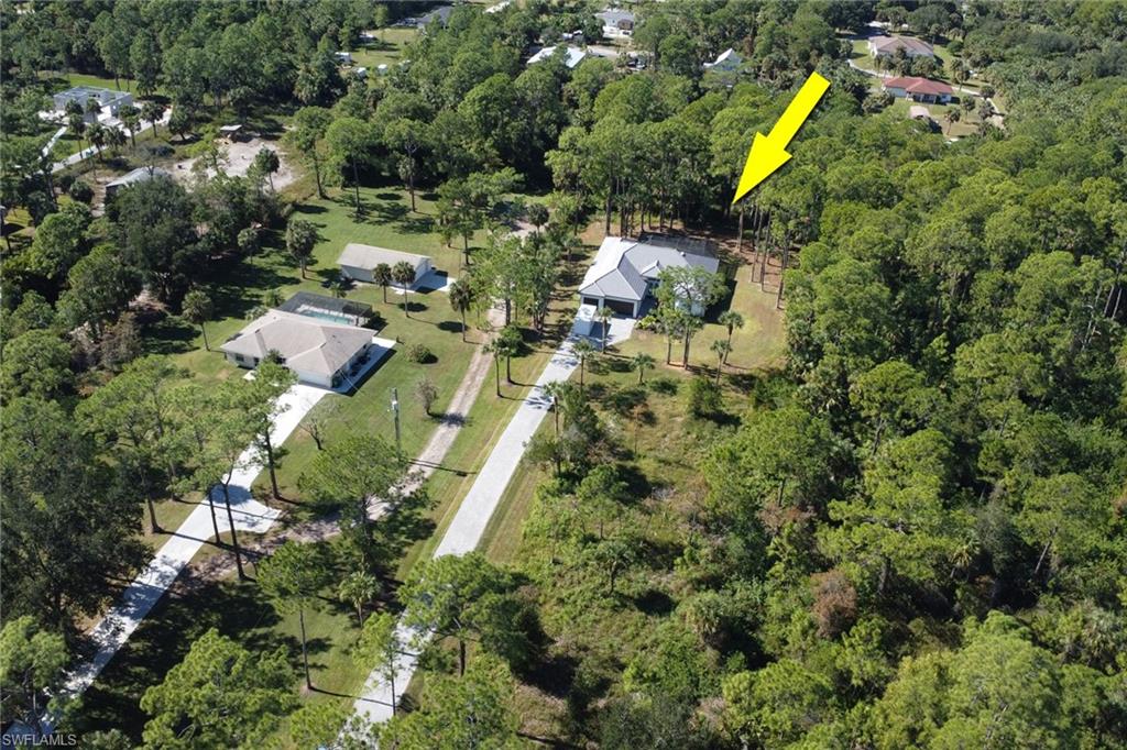 Aerial view of property and surrounding area with a heavily wooded area
