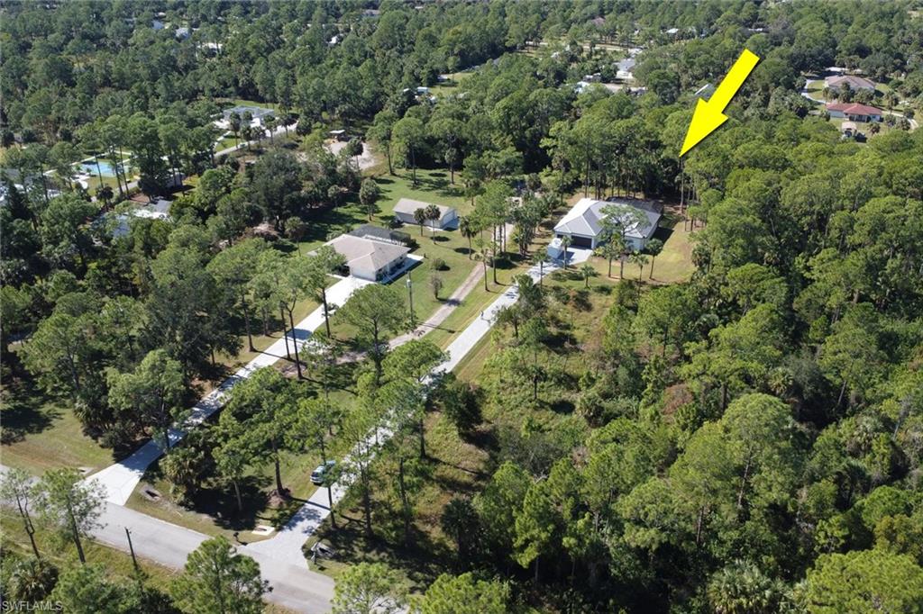 Aerial overview of property's location with a heavily wooded area