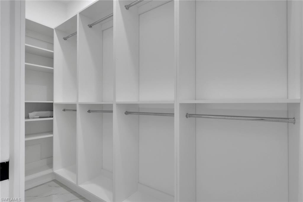 Spacious closet featuring marble look tiles
