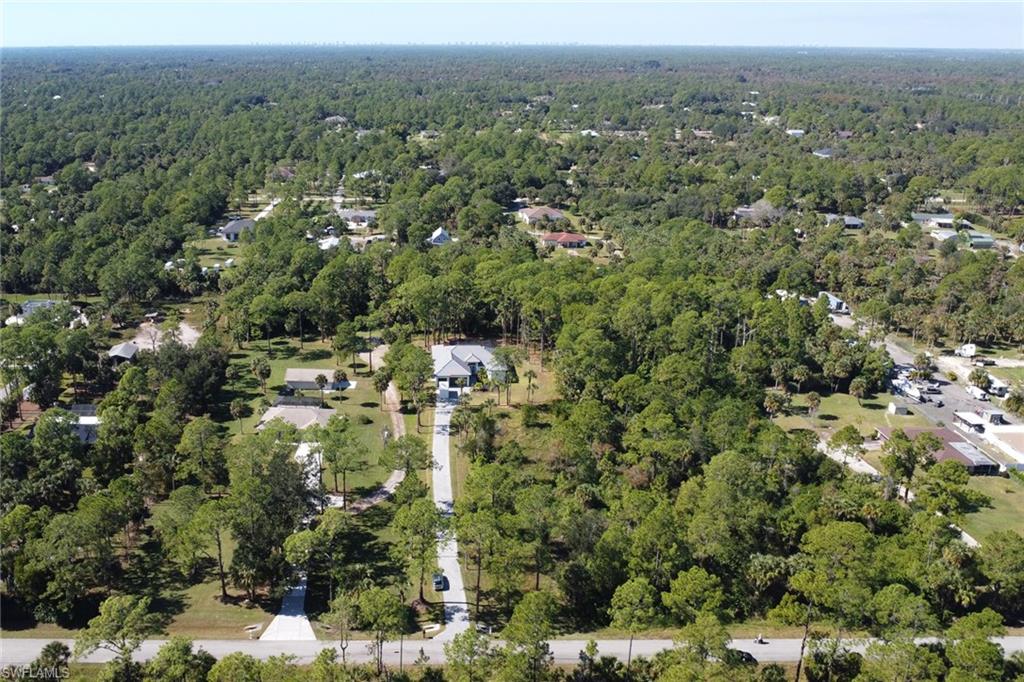 Aerial view of property and surrounding area featuring a forest