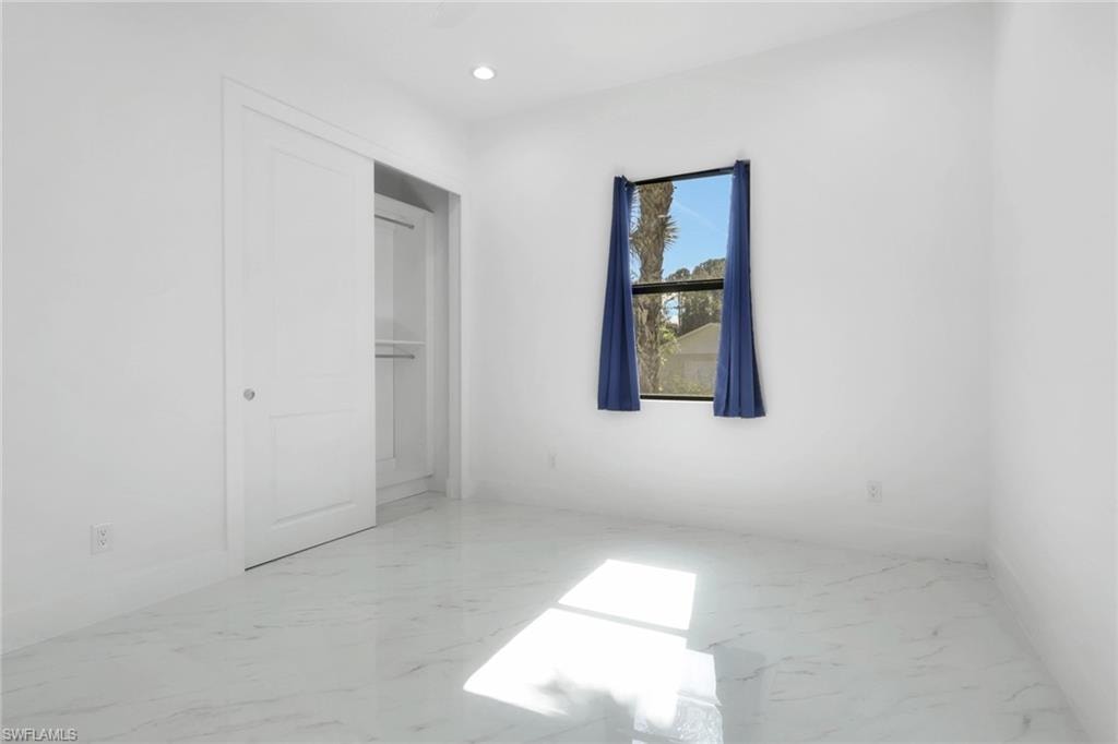 Unfurnished bedroom featuring light marble finish floors and recessed lighting