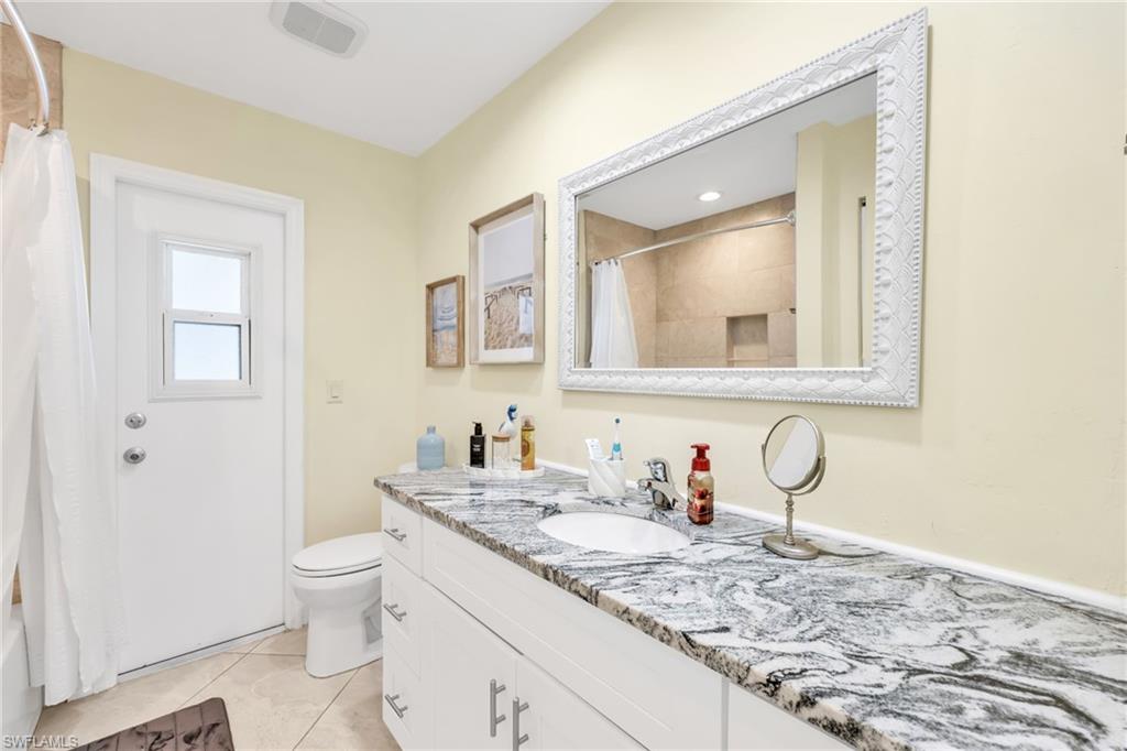 Bathroom featuring vanity, light tile patterned floors, and shower / bath combo