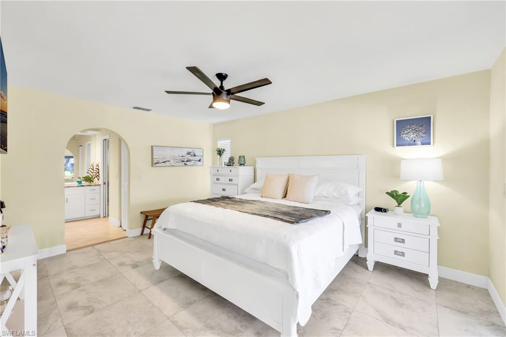 Bedroom featuring arched walkways and ceiling fan