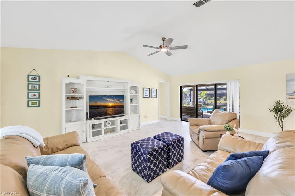 Tiled living room featuring lofted ceiling and a ceiling fan
