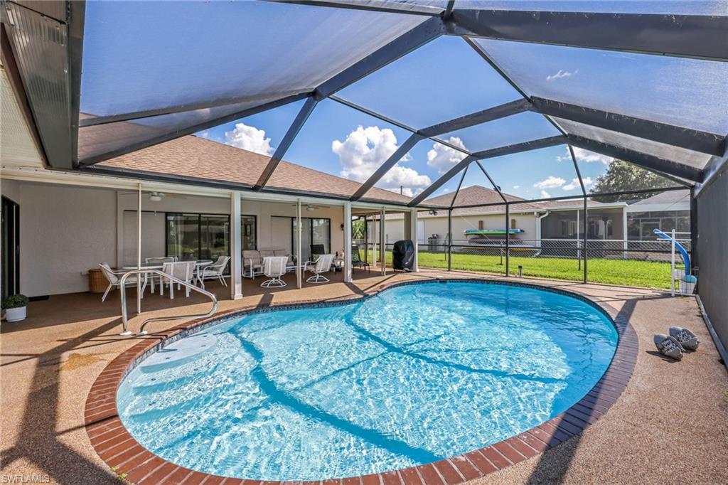 Swimming pool featuring a sunroom, a patio area, a ceiling fan, a lanai, and area for grilling