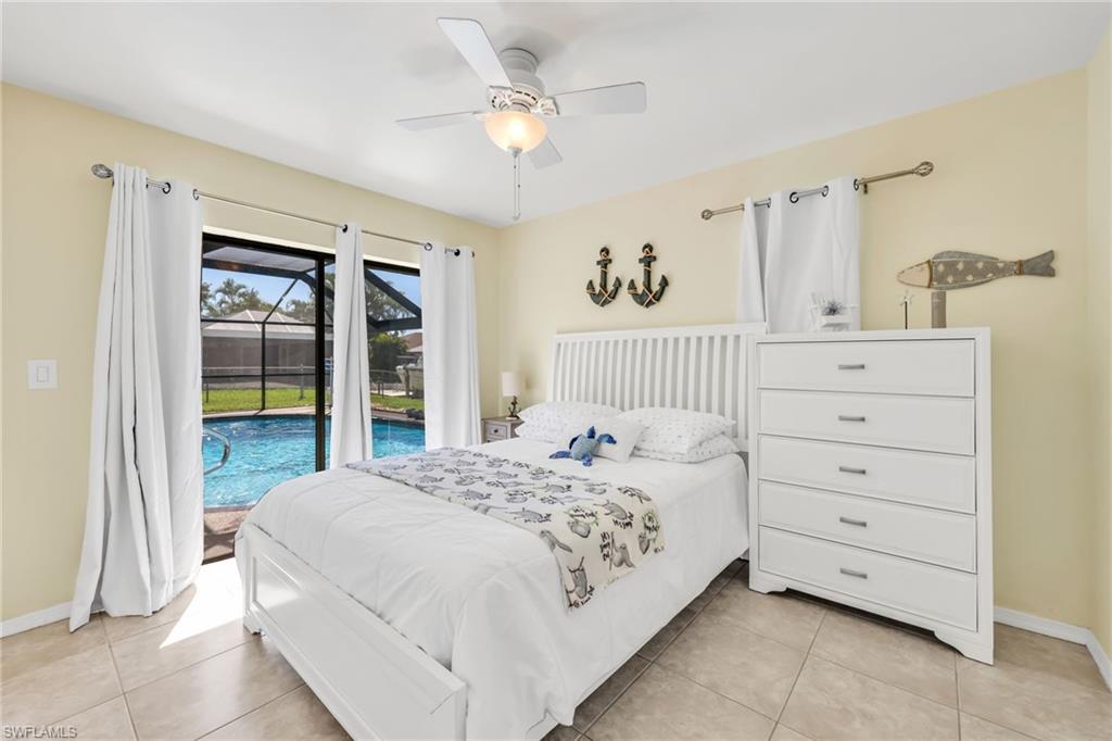 Bedroom with access to exterior, light tile patterned floors, and a ceiling fan