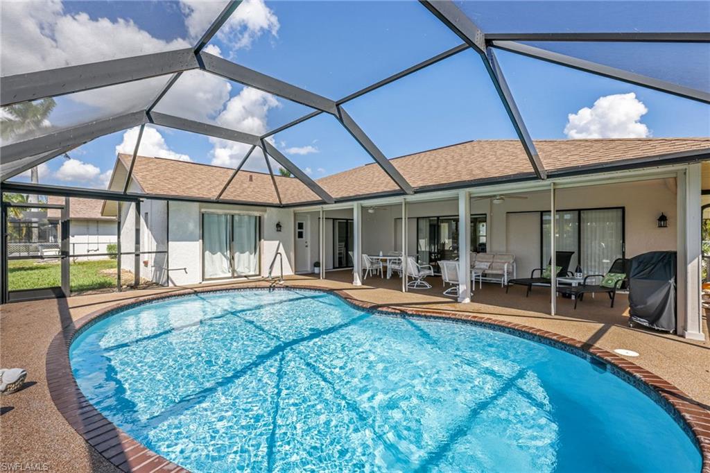 Swimming pool featuring a sunroom, a patio, glass enclosure, ceiling fan, and a grill
