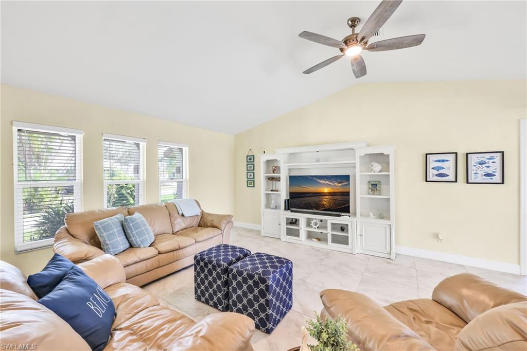 Living room featuring vaulted ceiling and ceiling fan