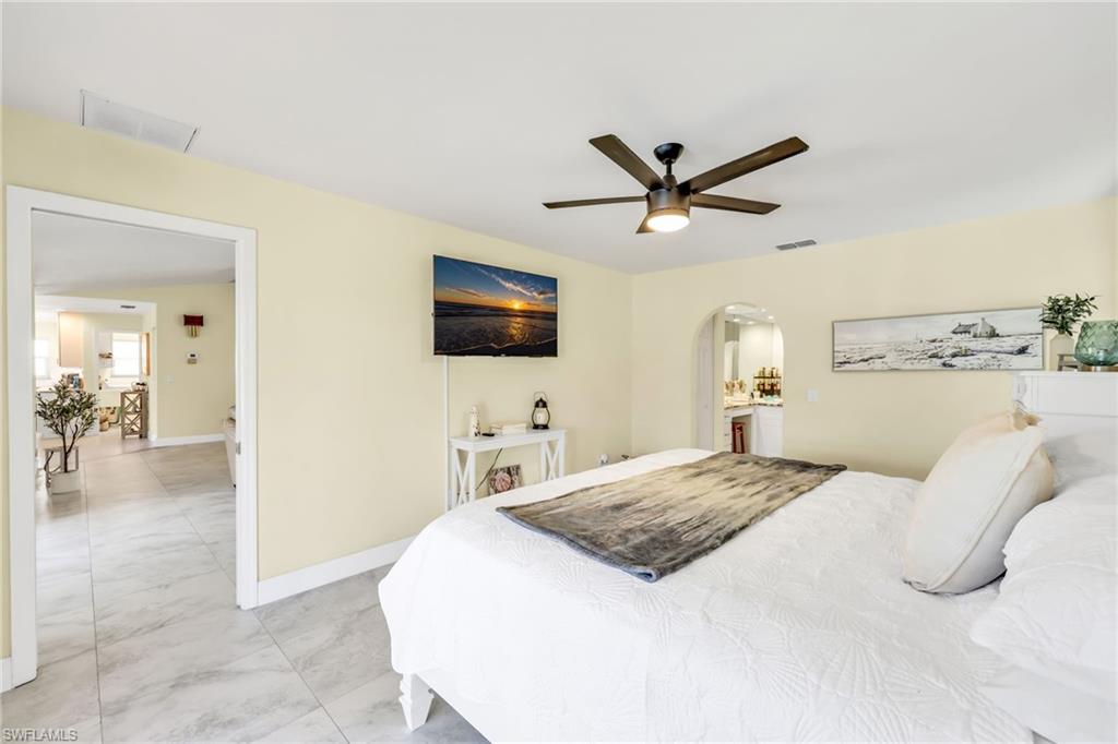 Bedroom featuring ceiling fan and arched walkways