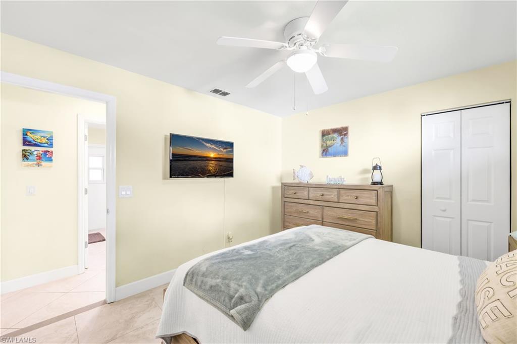 Bedroom with a closet, ceiling fan, and light tile patterned floors