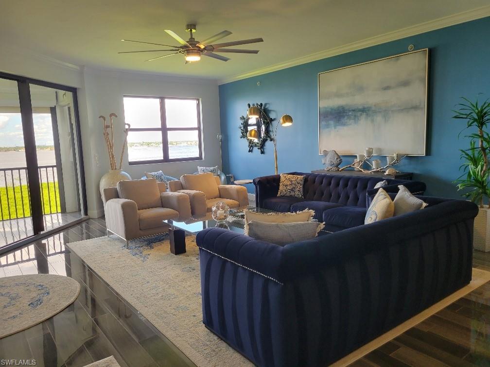 Living area with crown molding, wood finished floors, and a ceiling fan