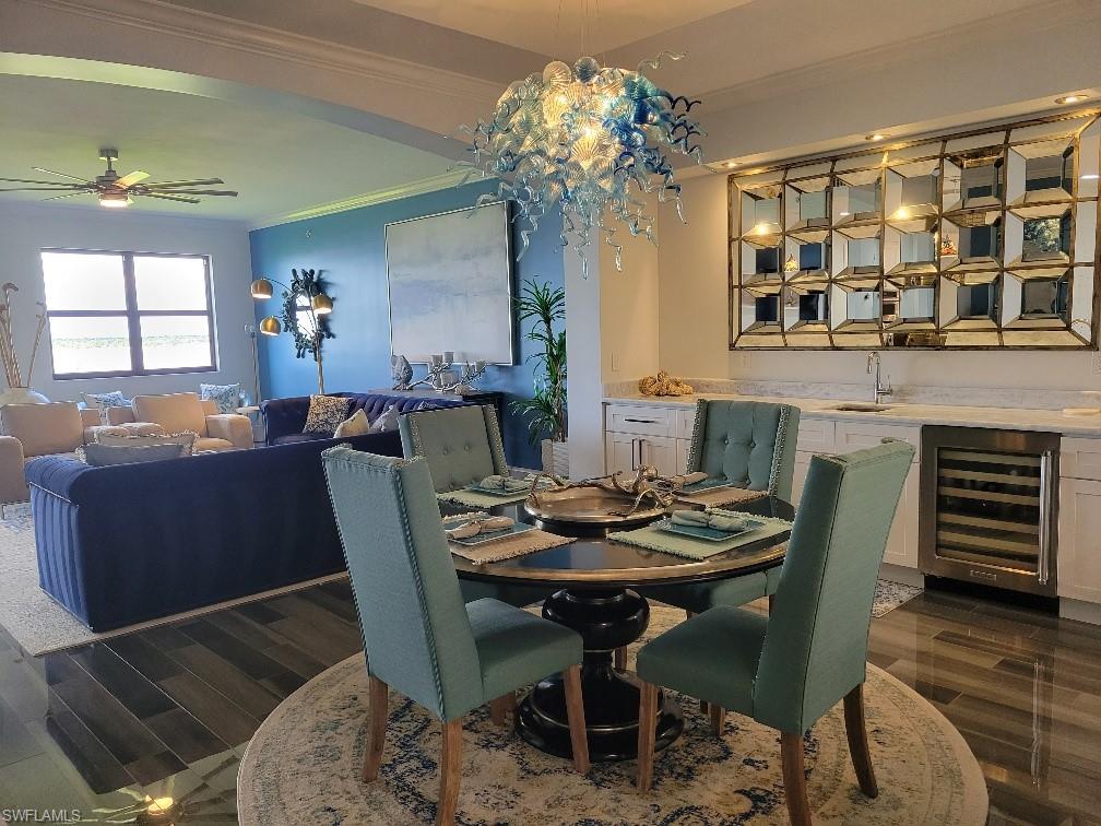 Dining space with crown molding, dark wood-type flooring, wine cooler, and ceiling fan