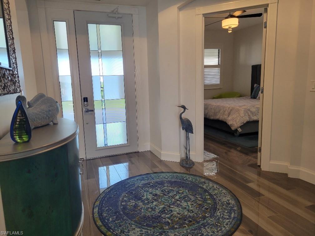 Doorway to outside with baseboards and wood finished floors