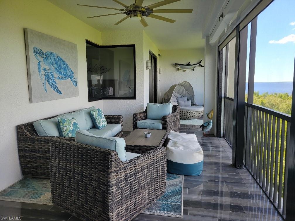 Sunroom / solarium featuring outdoor lounge area, a ceiling fan, and a water view