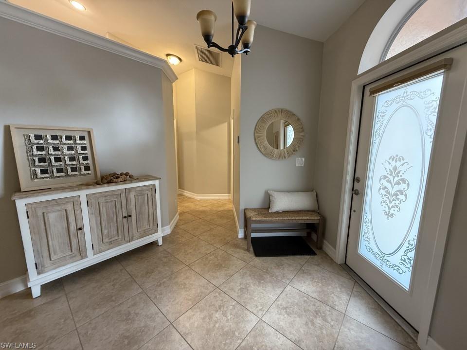 Foyer featuring a chandelier and light tile patterned floors