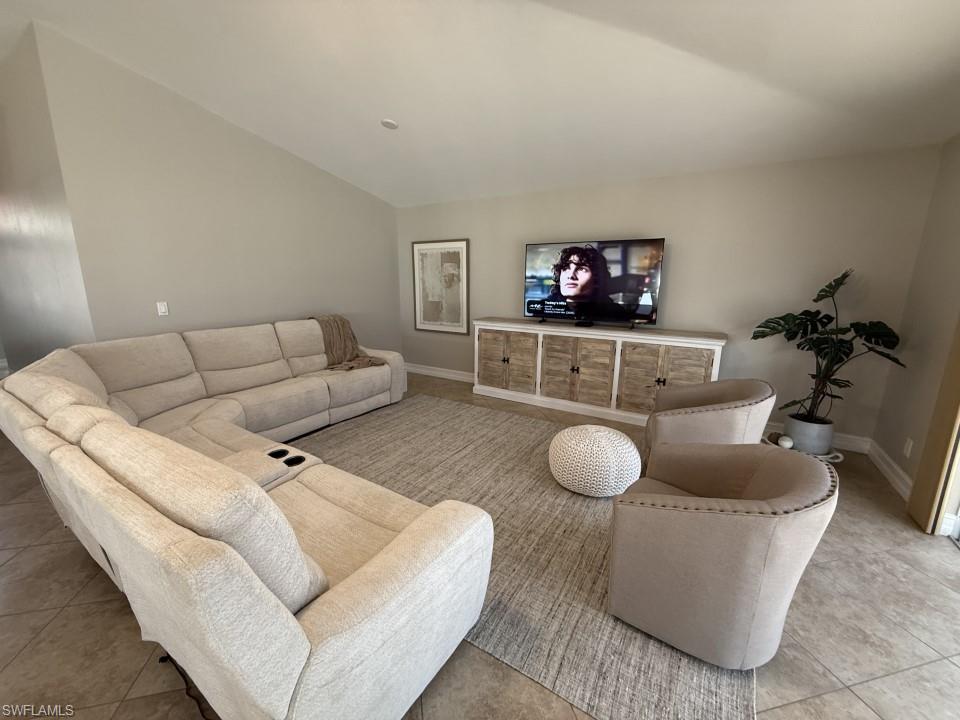 Living area featuring tile patterned flooring and lofted ceiling