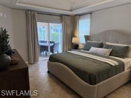 Bedroom with a tray ceiling, access to outside, and light tile patterned floors