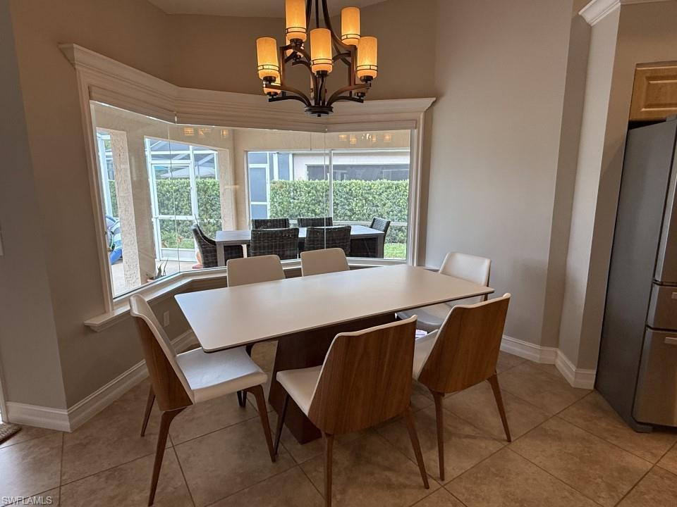 Dining area with plenty of natural light, a chandelier, and light tile patterned flooring