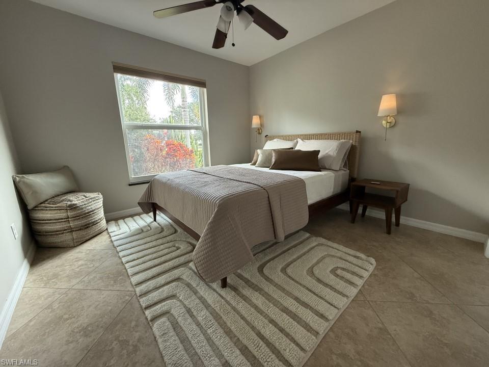 Guest Bedroom with ceiling fan and light tile patterned floors