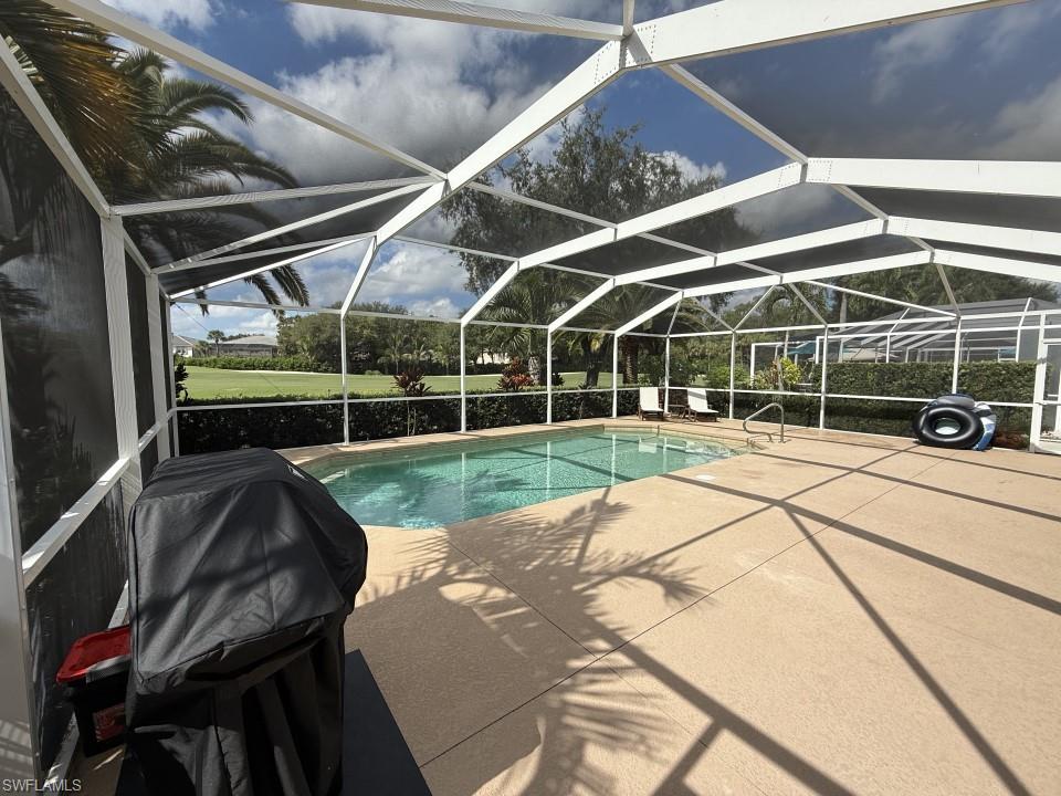 Swimming pool with a lanai, a sunroom, and a patio area