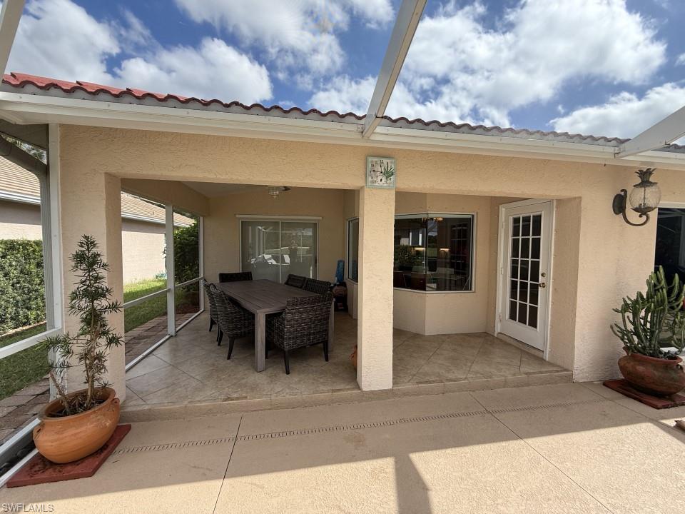 View of patio with a sunroom and outdoor dining space