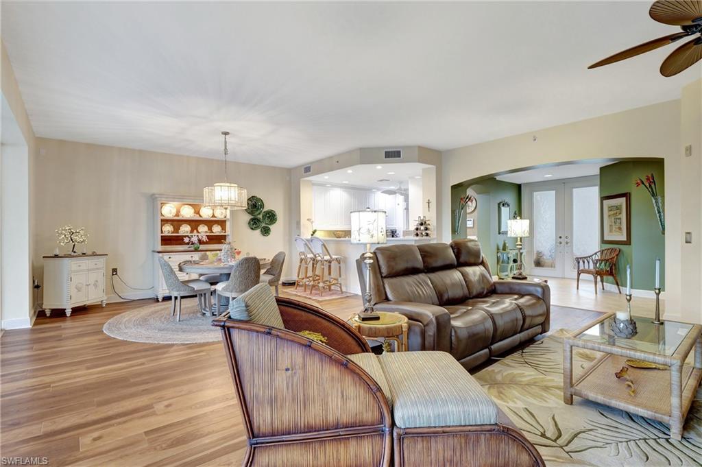 Living area featuring arched walkways, light wood-style floors, french doors, a ceiling fan, and recessed lighting