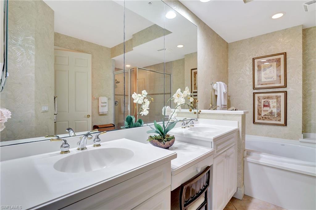 Full bath with double vanity, wallpapered walls, a stall shower, a garden tub, and recessed lighting